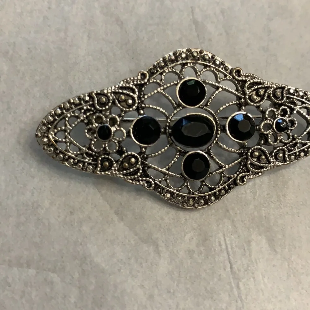Silver and black brooch